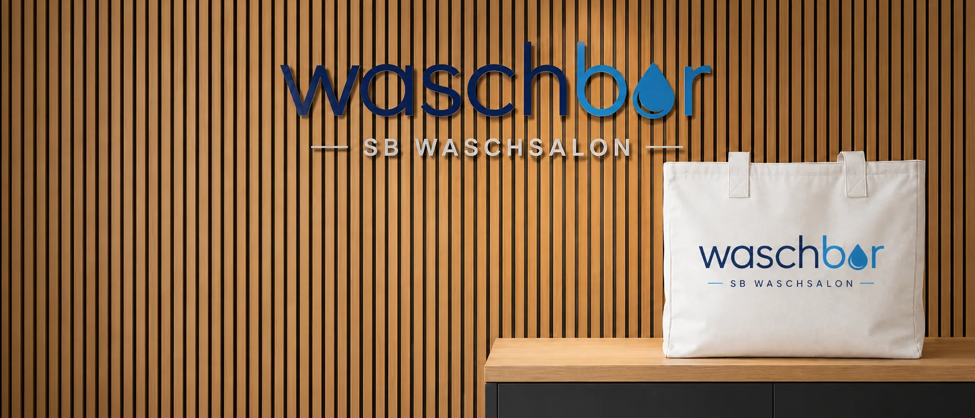 Waschbar SB Waschsalon Logo an Holzlamellenwand mit Waschbar Tragetasche